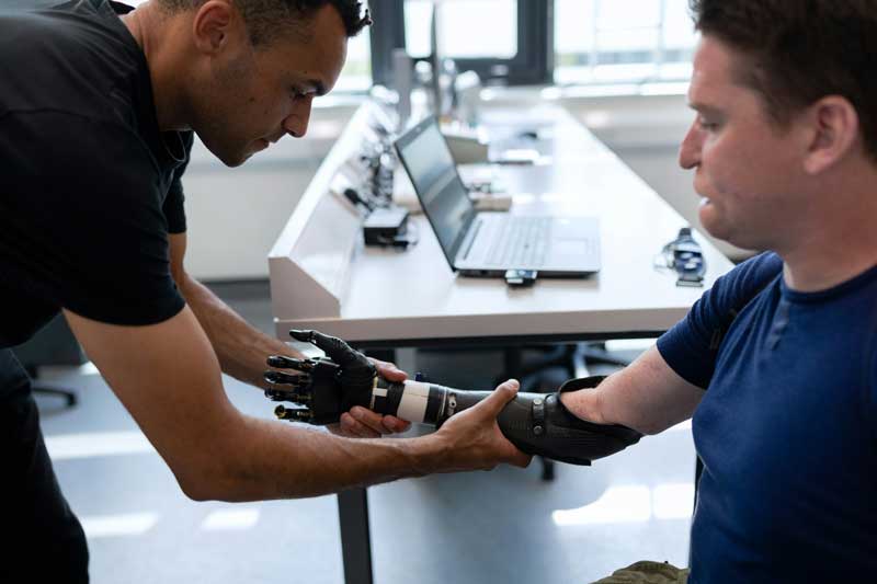 Physio helping patient with robot arm