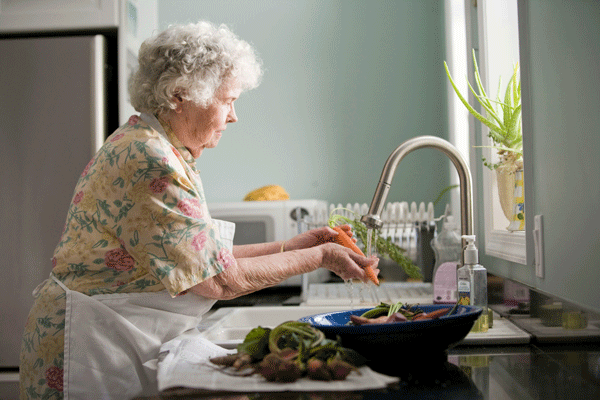 Elderly woman washing dishes