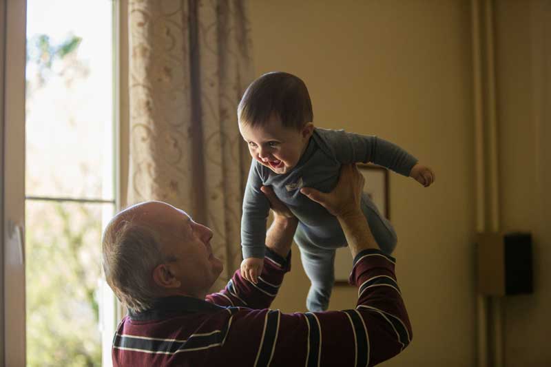 Grandfather holding his grandchild in the air