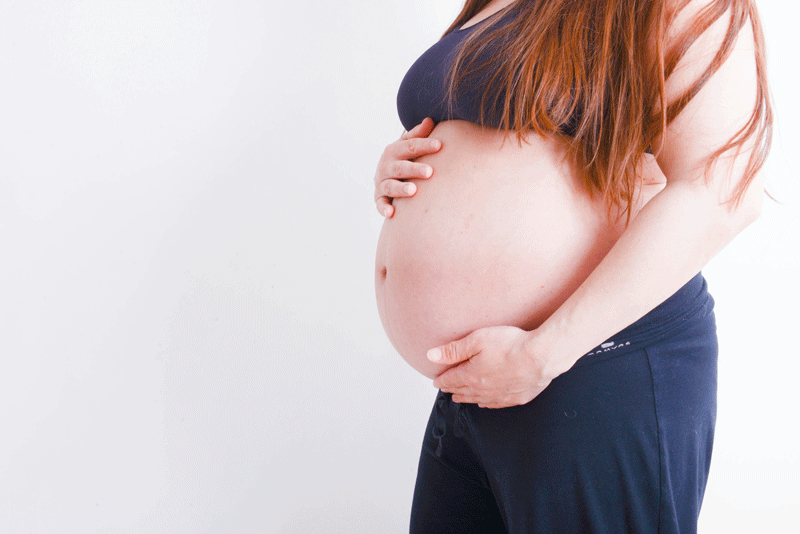 Pregnant woman holding stomach