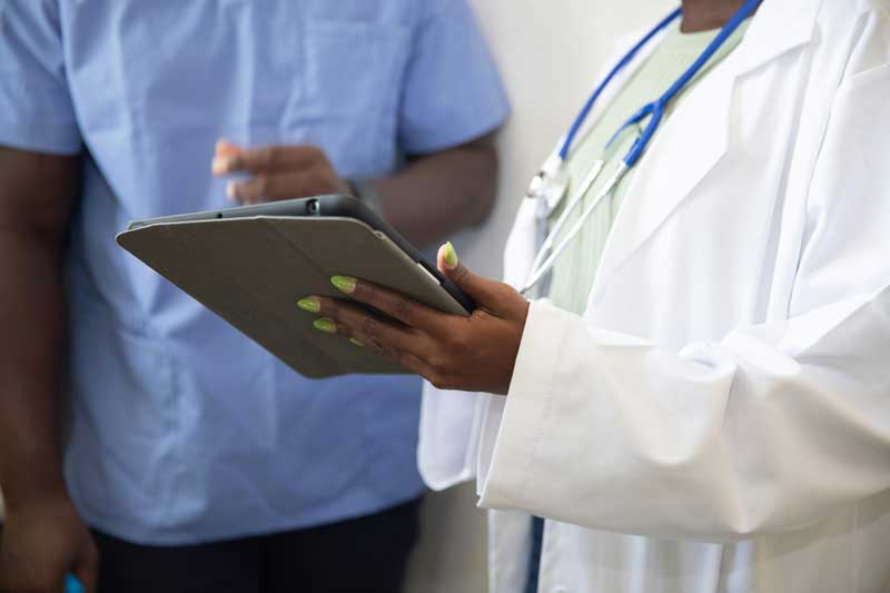 Woman holding clipboard next to another person