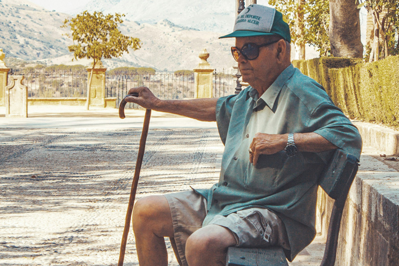Old man on bench with watch