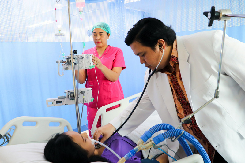 Dr helping ICU patient